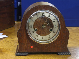 A 1930's 8 day striking mantel clock by Enfield with silvered dial and Arabic numerals contained in an oak arch shaped case