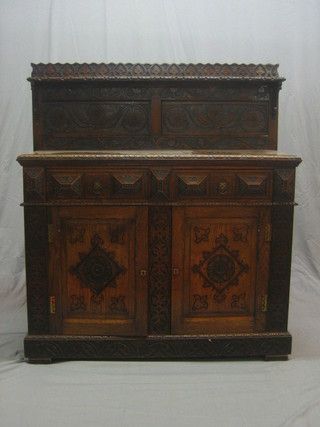 A Victorian carved oak chiffonier with raised back fitted a shelf, the base fitted 2 drawers above a double cupboard, 1 fitted a further range of drawers, raised on a platform base 47"
