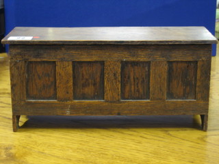 A miniature oak coffer with panel to the front and hinged lid 11"