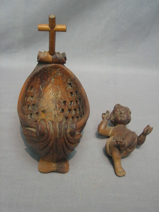 An 18th/19th Century carved lime wood figure of a reclining infant Christ 6", contained in a carved olive wood? boat shaped cradle