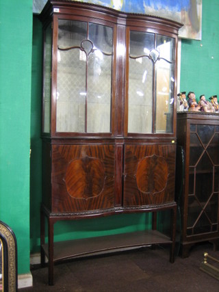 An Edwardian Georgian style mahogany display cabinet with moulded and gadrooned cornice, the interior fitted adjustable shelves and enclosed by astragal glazed doors, the base fitted a double cupboard enclosed by a panelled door with undertier beneath, raised on square supports, 41"