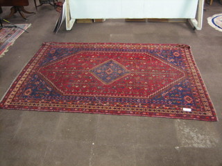 A contemporary red ground Persian carpet with central medallion within multi-row borders 120" x 82"