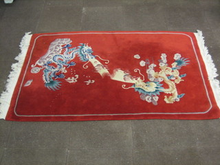 A red ground Chinese rug decorated 2 dragons 73" x 47"