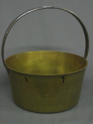A brass preserving pan with polished steel handle and a brass ladle