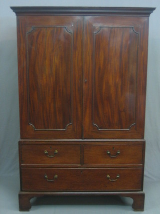 A Georgian mahogany linen press with moulded cornice the interior minus trays enclosed by panelled doors, the base fitted 2 short drawers above 2 long drawers, raised on bracket feet 48"