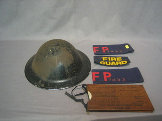 A WWII steel helmet, 2 arm bands marked SFP, 2 pairs of anti gas goggles