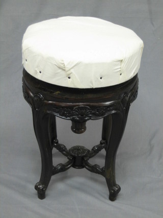 A Victorian carved mahogany revolving adjustable piano stool, raised on cabriole supports