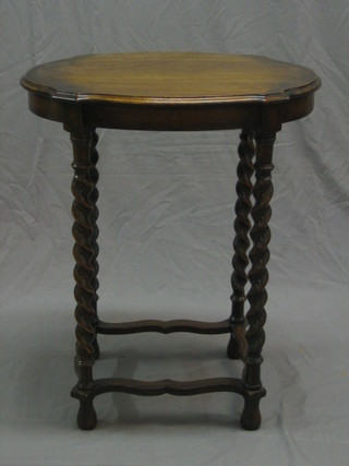 A 1930's honey oak oval occasional table, raised on spiral turned supports 24"