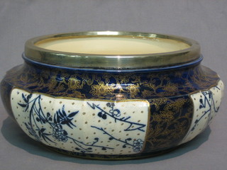 A circular Royal Doulton blue and white glazed bowl with floral decoration, the base marked Royal Doulton England and impressed Doulton Slater patent with silver plated rim 11"