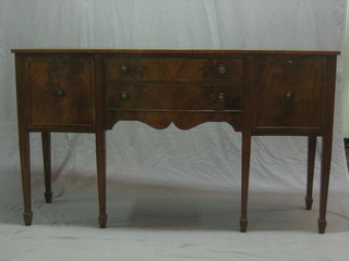 A Georgian style mahogany sideboard of serpentine outline fitted 2 drawers flanked by a double cupboard, raised on square supports ending in spade feet 63"