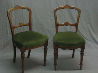 A set of 4 Edwardian rail back dining chairs with carved mid rails and upholstered seats, raised on turned and fluted supports