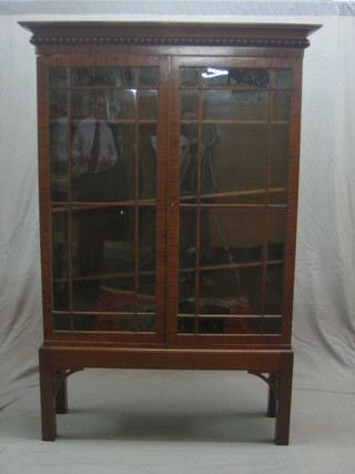 A Georgian mahogany Chippendale style cabinet on stand with moulded cornice, the interior fitted adjustable shelves enclosed by an astragal glazed door, raised on square tapering supports 48"