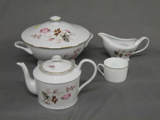 An 84 piece Limoges white porcelain dinner service with pink rose decoration comprising twin handled soup tureen and cover 11", circular bowl 11", pedestal bowl 10", oval meat plate 16", 2 oval platters 9 1/2", a large circular serving plate 12", a twin handled bread plate 12", 12 dinner plates 10", 12 soup bowls 9", 12 pudding bowls 7", 12 tea plates 6", a sauce boat, teapot, lidded sucrier and cream jug, 12 cups and 12 saucers 