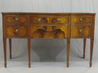A Georgian style mahogany sideboard of serpentine outline, fitted 2 long drawers flanked by a double cupboard, raised on square tapering supports ending in spade feet 60"