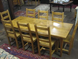 A 20th Century solid honey oak dining suite comprising a rectangular dining table raised on square supports 87" and a set of 8 ladder back dining chairs