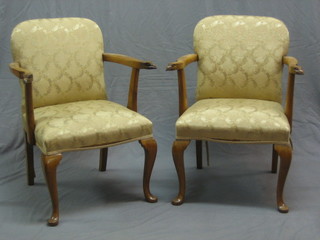 A pair of 1950's walnut Georgian style open arm chairs, the arms carved eagles heads and raised on cabriole supports