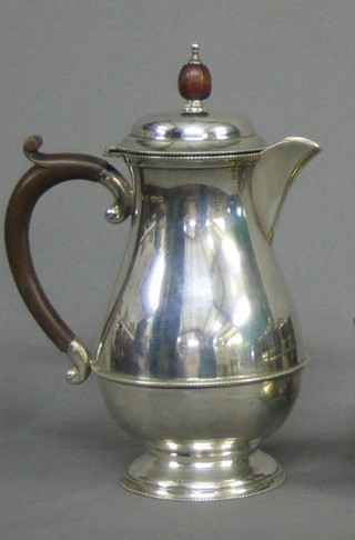 A silver hotwater jug of baluster form with beech handle Birmingham 1931, 11 ozs    