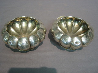 A pair of Victorian embossed melon shaped silver salts/sugar bowls, raised on spreading feet London 1850, 6 ozs