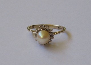 A lady's 9ct gold dress ring set a pearl supported by small diamonds