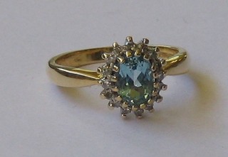 A lady's gold dress ring set an oval cut aquamarine supported by diamonds