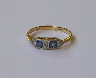 An 18ct gold dress ring set 2 square cut sapphires supported by 4 diamonds