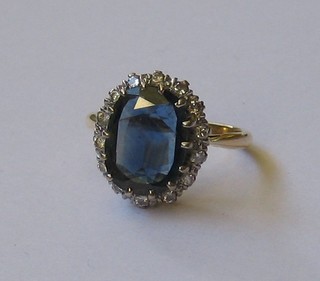 An 18ct gold dress ring set a large blue stone supported by numerous diamonds