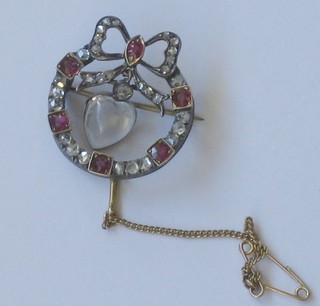 A Victorian gold brooch set diamonds and rubies and with a heart shaped cabouchon cut moonstone to the centre