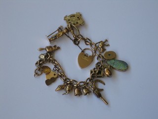 A 9ct gold curb link charm bracelet hung 19 various charms with gold padlock clasp  