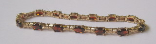 A lady's 9ct gold bracelet set red stones
