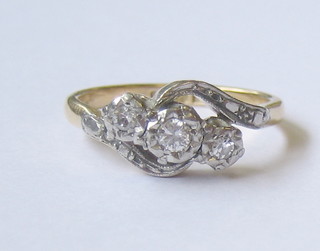 A lady's 18ct gold cross-over dress ring with 3 illusion set diamonds