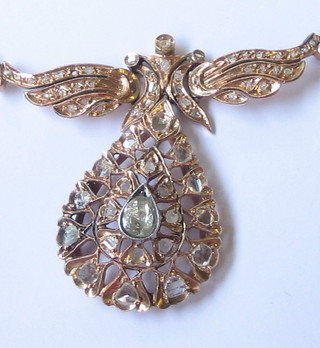 A handsome oval pierced gold pendant set 21 old cut diamonds surmounted by wings, set diamonds (3 missing)