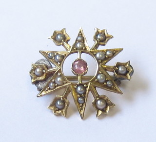 A 15ct gold brooch in the form of a star set demi-pearls and amethyst