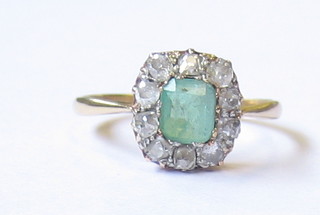 A lady's gold dress ring set emeralds supported by diamonds