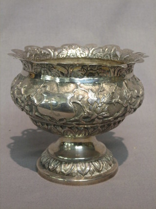 A circular Eastern embossed silver bowl raised on a spreading foot, 9 ozs