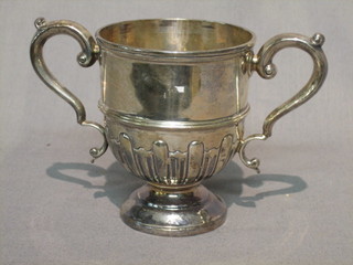 A Victorian silver twin handled trophy cup with embossed body raised on a circular spreading foot, Sheffield 1899, 6 ozs