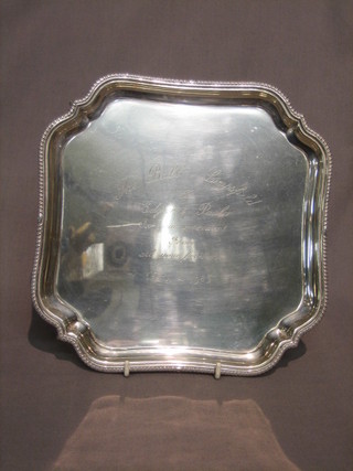 A square silver salver with bracketed border, raised on 4 ball and claw feet, London 1934 by the Goldsmiths & Silversmiths Co. 20ozs
