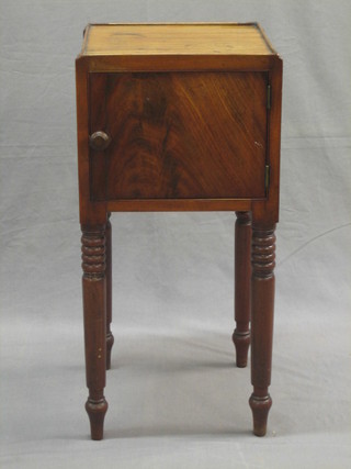 A 19th Century mahogany pot cupboard enclosed by panelled door, raised on turned supports 13"