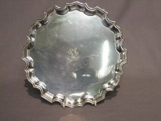 A circular silver salver with bracketed border raised on 3 scrolled feet, London 1918, 20 ozs