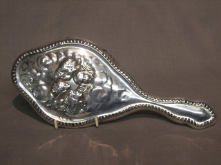 An Edwardian silver backed hand mirror embossed Botticcelli angels, London 1900