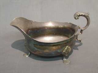 A large Georgian style silver plated sauce boat with armorial decoration, raised on hoof feet