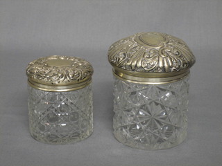 A circular cut glass dressing table jar with silver lid and 1 other