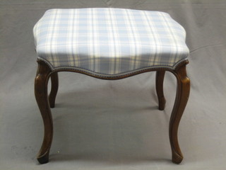 A  Victorian walnut stool of serpentine outline, with upholstered seat, raised on cabriole supports