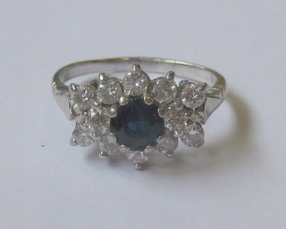 An 18ct white gold dress ring set a sapphire surrounded by diamonds