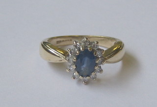 A 9ct gold dress ring set an oval sapphire surrounded by diamonds