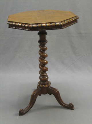 A Victorian octagonal mahogany wine table, raised on a walnut spiral turned column and tripod base 18"