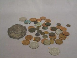 A silver plaque and a collection of various coins