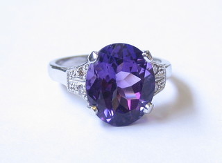 An 18ct gold dress ring set an oval cut amethyst and 4 diamonds to the shoulders, (approx 4.2ct)