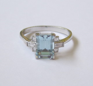 A lady's 18ct white gold dress ring set a rectangular cut aquamarine and 2 baguette cut diamonds to the shoulders and 4 further diamonds
