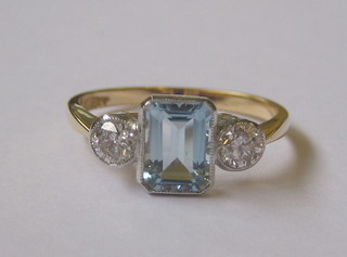 An 18ct yellow gold dress ring set a rectangular cut aquamarine supported by 2 diamonds