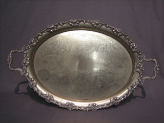 An oval silver plated twin handled tea tray with vinery decoration 26"
